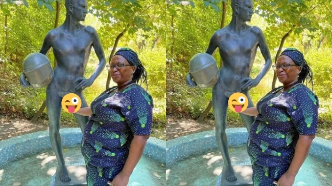 “She Go Like Am” – Netizen Reacts To Photos Of An Elderly Woman Holding A Third Leg Of A Molded Statue